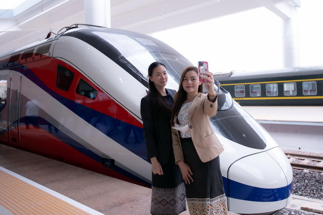 10月16日，兩名女子在老撾萬象站與“瀾滄號”動車組合影。新華社發(fā)（凱喬攝）