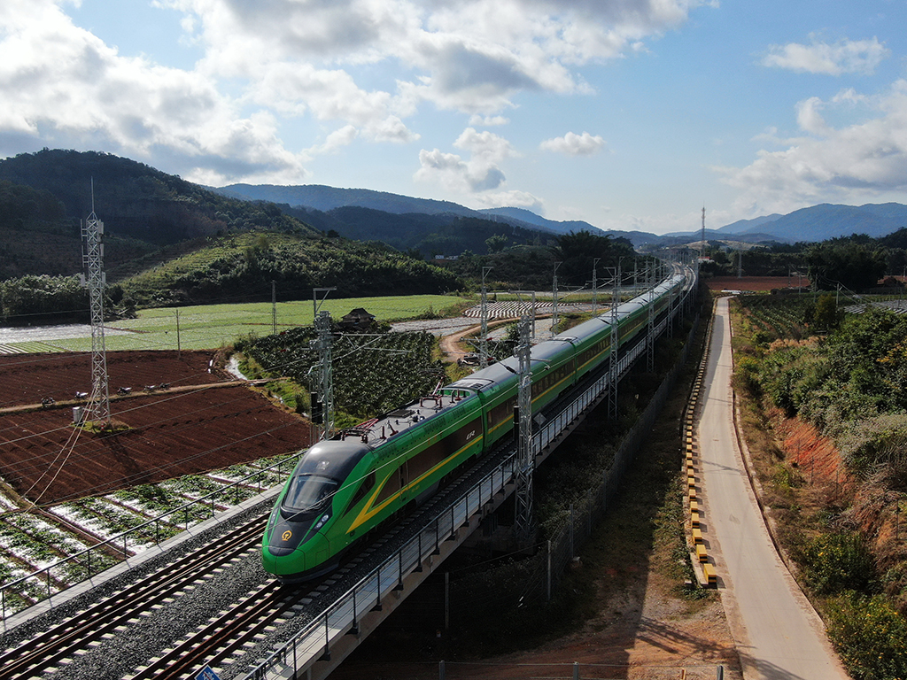 1月3日，列車行駛在位于云南西雙版納傣族自治州景洪市境內(nèi)的中老鐵路上（無人機照片）。新華社發(fā)（李云生攝）