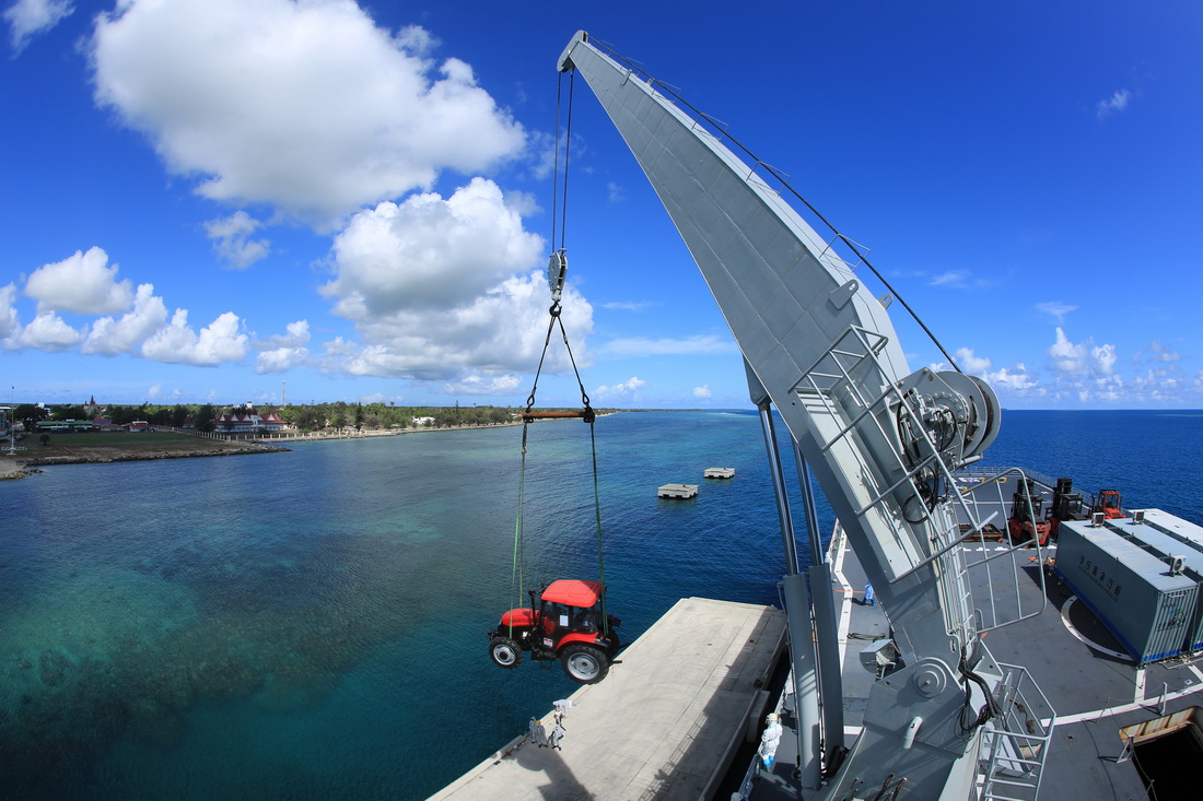 赴湯加執(zhí)行運(yùn)送救災(zāi)物資任務(wù)的中國海軍艦艇編隊在努庫阿洛法港卸載拖拉機(jī)（2月19日攝）。新華社發(fā)（薛成清 攝）