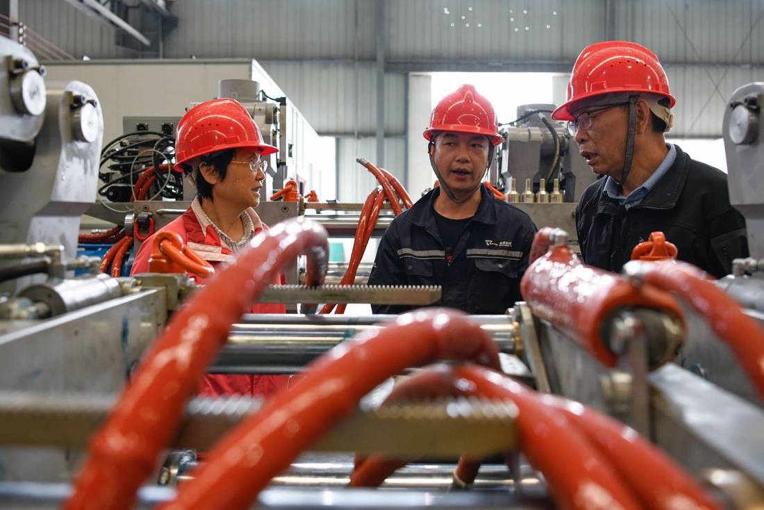 5月27日，戴虹（左）和黃正中（右）在裝配車(chē)間內(nèi)向工人了解近期裝配情況。新華社記者 胥冰潔 攝