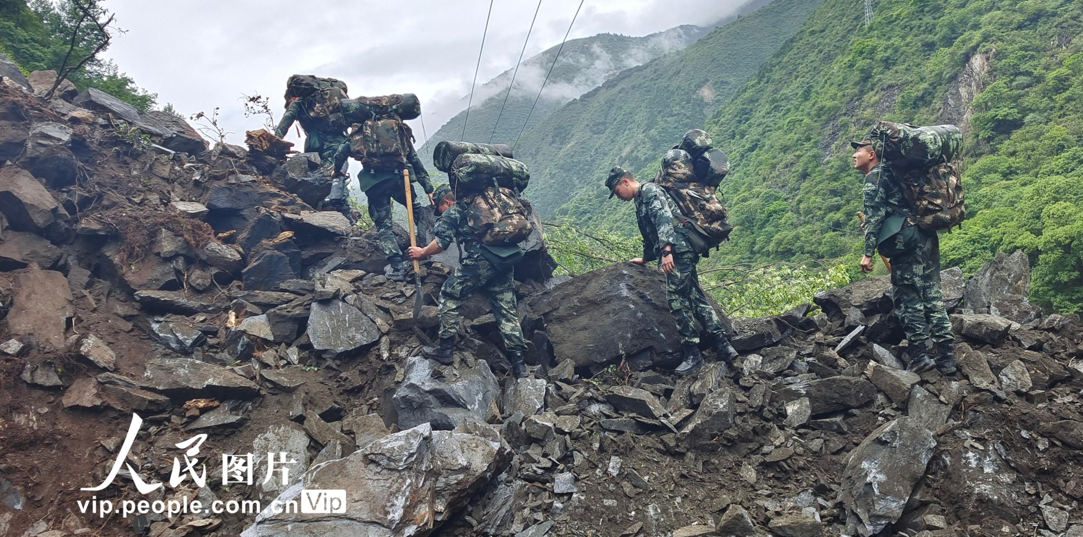 2022年6月11日，武警阿壩支隊官兵徒步向震中草登鄉(xiāng)開進(jìn)。