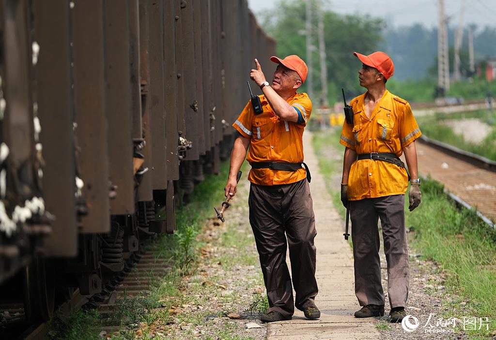 8月4日，酷暑下鐵路天津車輛段檢車人員在車輛現(xiàn)場(chǎng)進(jìn)行檢車作業(yè)。楊寶森攝