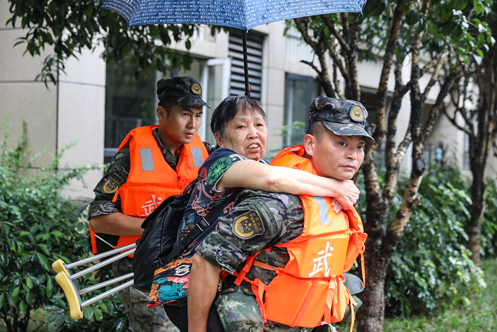 7月14日，在重慶市萬州區(qū)江南新區(qū)，武警重慶總隊(duì)執(zhí)勤第三支隊(duì)官兵在轉(zhuǎn)移群眾。新華社發(fā)（黃赟 攝）