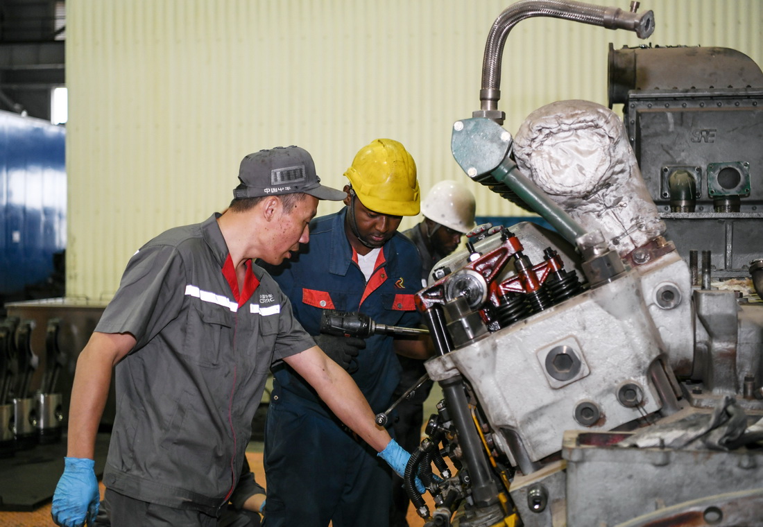 7月4日，在肯尼亞內(nèi)羅畢的蒙內(nèi)鐵路機(jī)車維保車間，中國中車駐肯員工和肯方員工檢修機(jī)車柴油機(jī)。