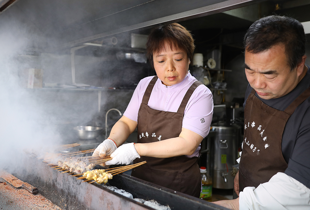 5月1日，程亞娟（左）和丈夫鐘萬慧在后廚為客人備餐。