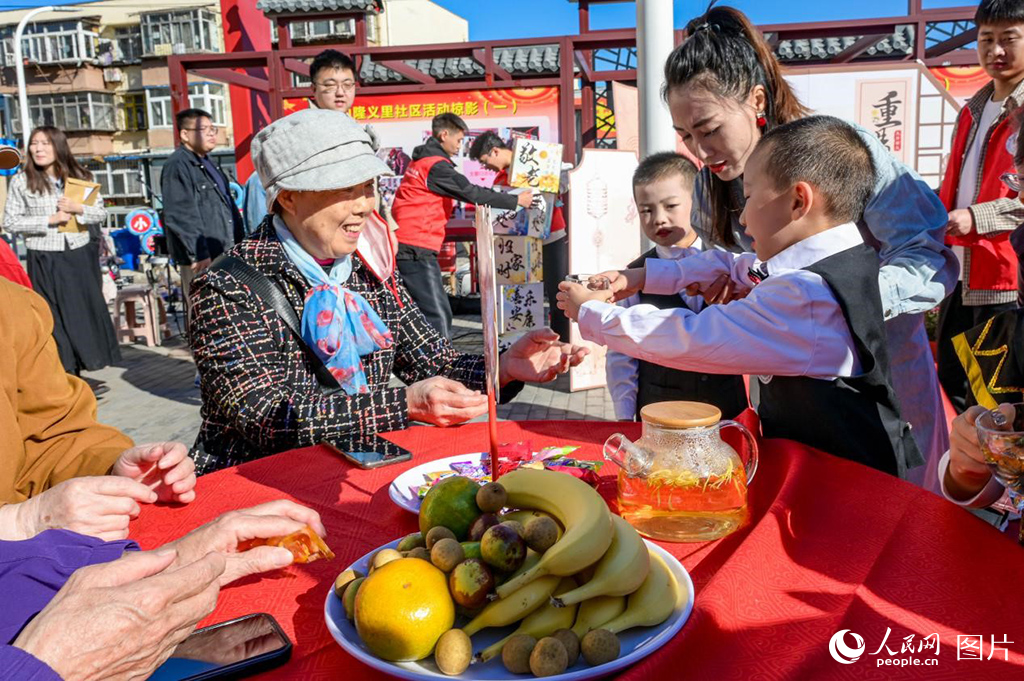 10月10日，“我們的節(jié)日·重陽(yáng)”新時(shí)代文明實(shí)踐活動(dòng)在河北省唐山市路南區(qū)舉辦。活動(dòng)現(xiàn)場(chǎng)，東新街小學(xué)附屬幼兒園的孩子給老人敬菊花茶。人民網(wǎng)記者 周博攝