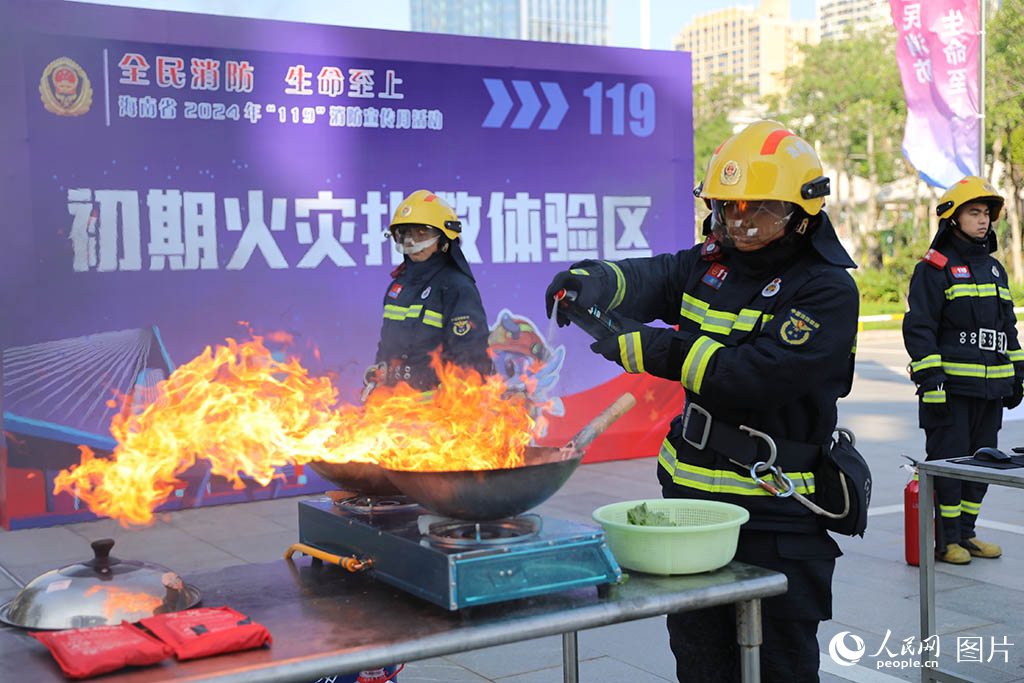 11月8日，海南省“119”消防宣傳月活動(dòng)啟動(dòng)儀式在?？谑信e行，圖為消防員演示油鍋起火的撲救方式。 人民網(wǎng)記者 孟凡盛攝