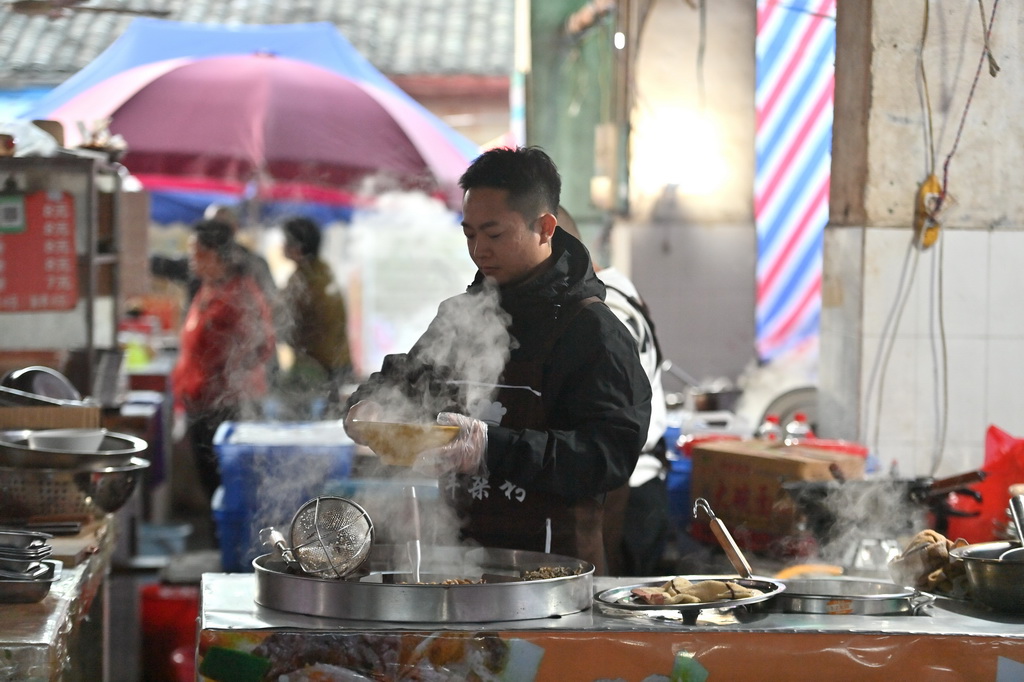 在柳州市柳江區(qū)成團(tuán)鎮(zhèn)農(nóng)貿(mào)市場早市，早餐攤主為顧客準(zhǔn)備食材（11月20日攝）。新華社記者 黃孝邦 攝