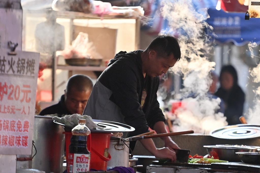 在柳州市柳江區(qū)成團鎮(zhèn)農(nóng)貿(mào)市場早市，早餐攤主為顧客準備食材（11月20日攝）。新華社記者 黃孝邦 攝