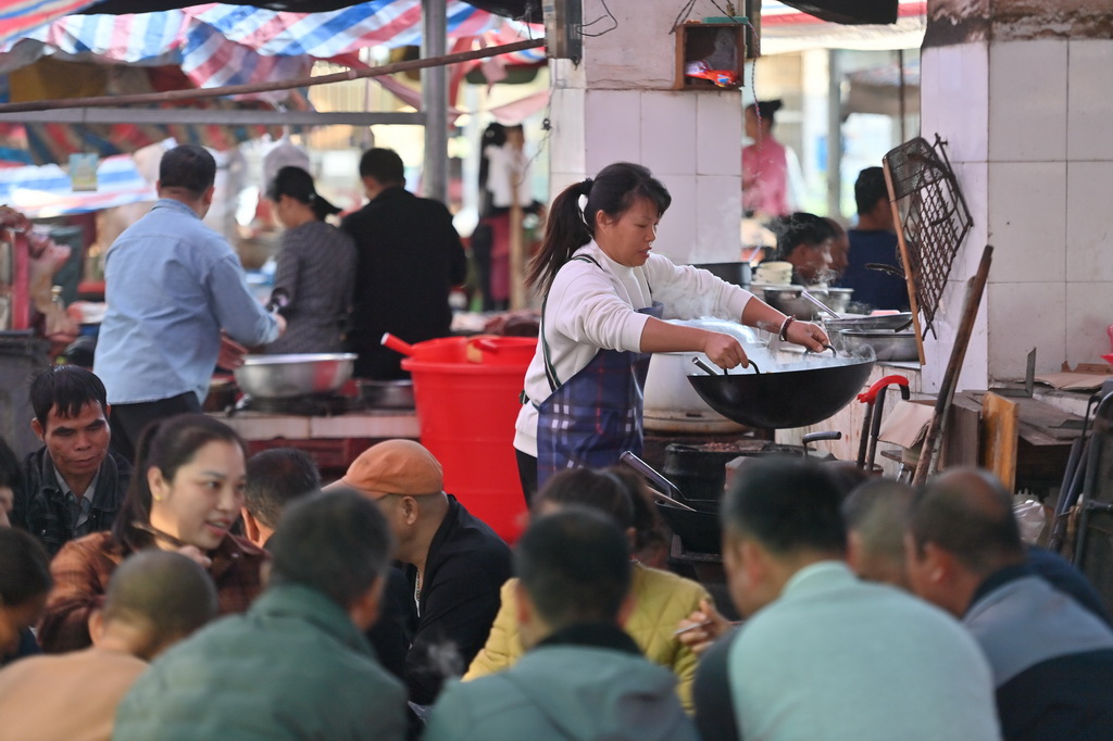 在柳州市柳江區(qū)成團(tuán)鎮(zhèn)農(nóng)貿(mào)市場早市，早餐攤主為顧客準(zhǔn)備食材（11月19日攝）。新華社記者 黃孝邦 攝