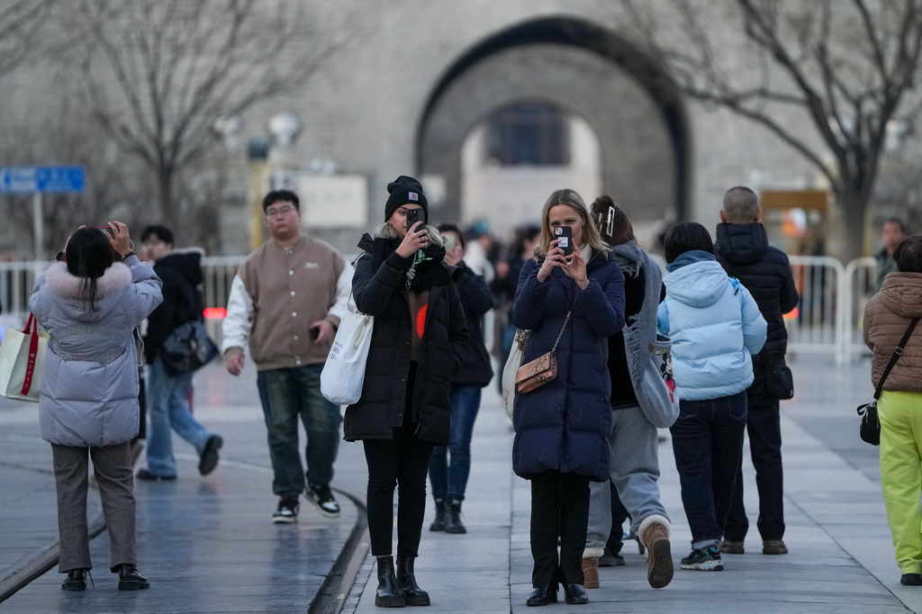 12月4日，兩名來自德國的游客在北京前門大街拍照，她們還將前往上海和桂林游玩。新華社記者 鞠煥宗 攝