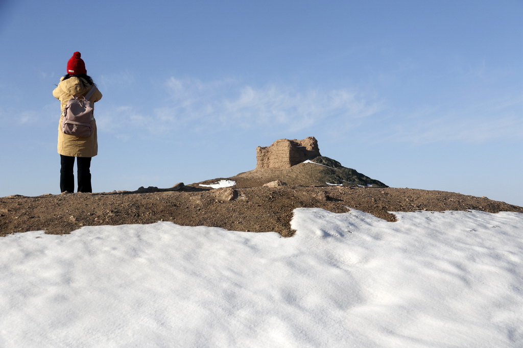 12月14日，游客在雪后的甘肅省敦煌市陽關(guān)景區(qū)游覽拍照。新華社發(fā)（張曉亮攝）