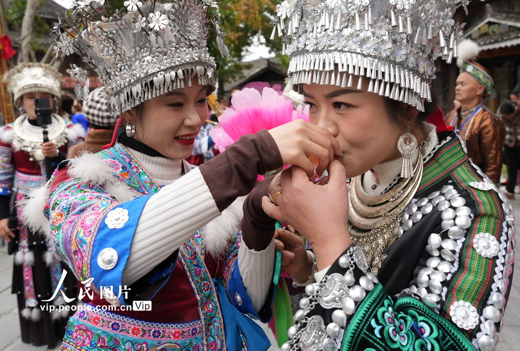 12月22日，在廣西柳州市融水苗族自治縣融水鎮(zhèn)夢嗚苗寨，主寨“同年”（左）在“迎同年”儀式中向客寨“同年”敬進寨酒。