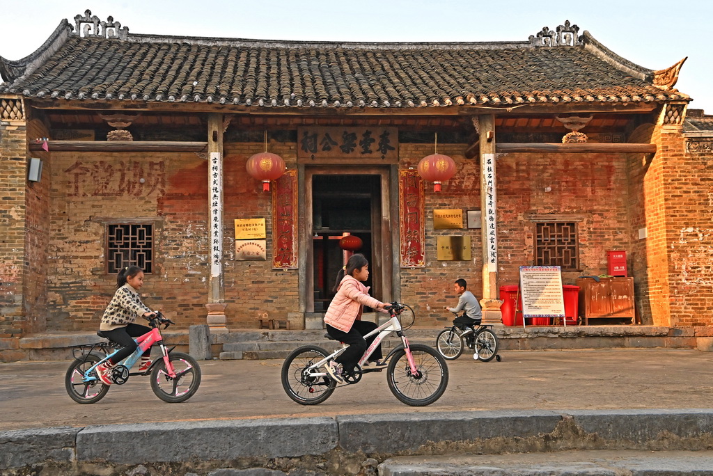 金秀縣桐木鎮(zhèn)那安村龍騰屯的孩子們在騎自行車（12月18日攝）。