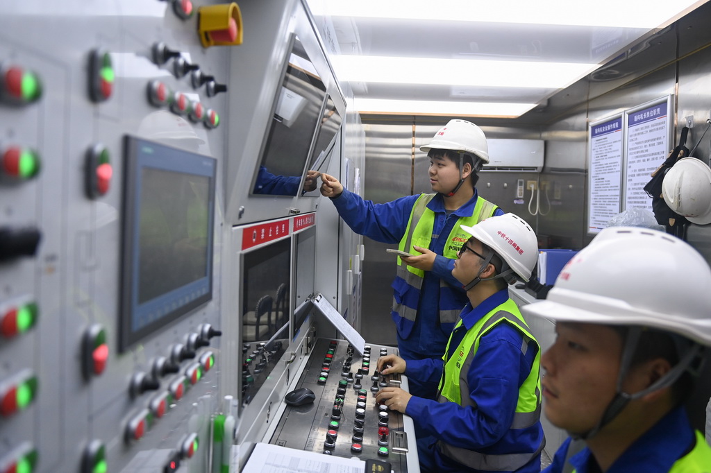 12月24日，中鐵十四局技術(shù)人員在甬舟鐵路金塘海底隧道“甬舟號(hào)”盾構(gòu)機(jī)操作室調(diào)整設(shè)備運(yùn)行參數(shù)。