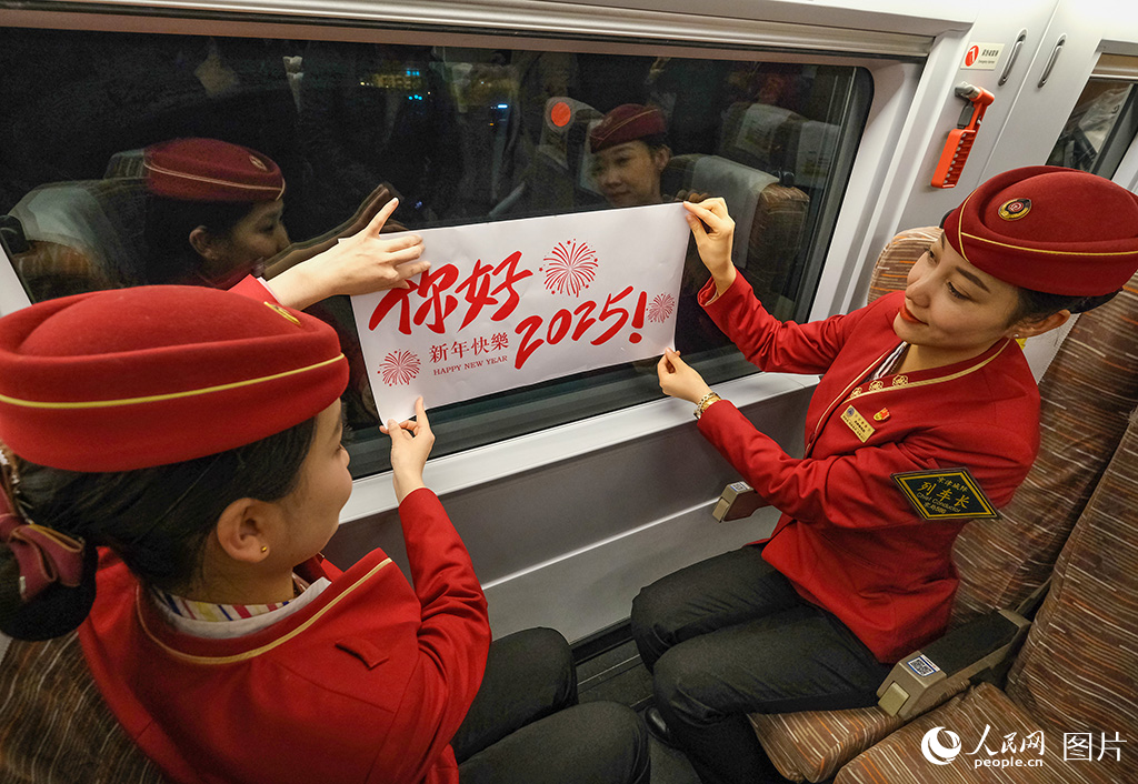 12月30日，乘務人員布置車廂粘貼迎新年窗貼。