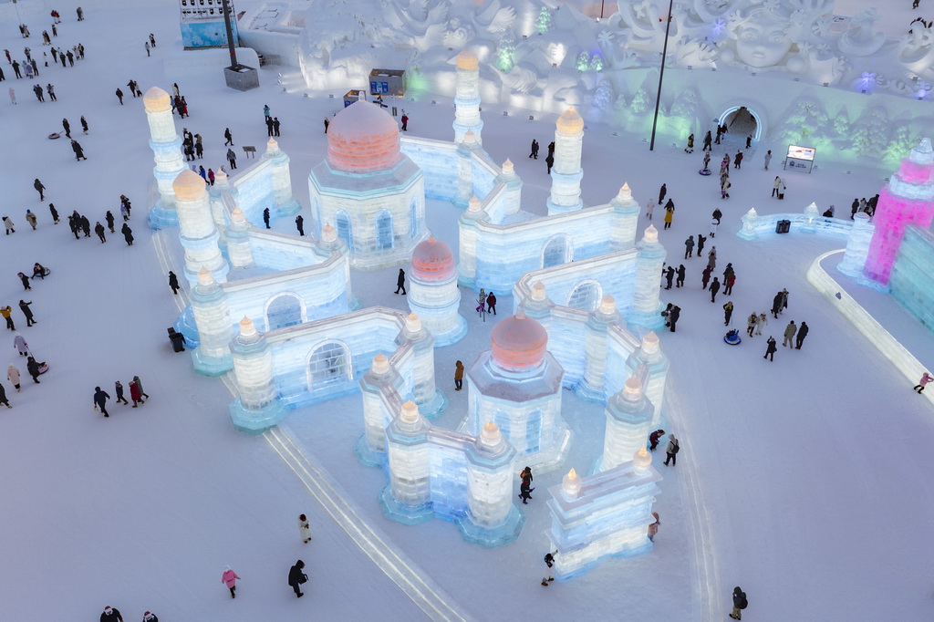 1月5日，在哈爾濱冰雪大世界園區(qū)，游客在一處大型冰建景觀附近游玩（無人機(jī)照片）。新華社記者 謝劍飛 攝