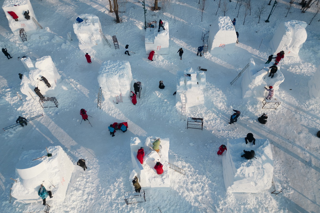 1月6日，參賽選手在哈爾濱太陽島雪博會園區(qū)進(jìn)行雪雕創(chuàng)作（無人機照片）。新華社記者 張濤 攝