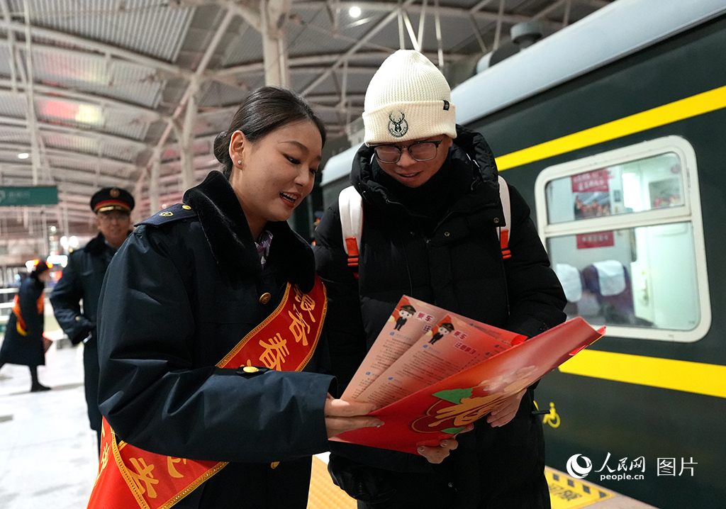 2025年春運(yùn)首日，銀川火車站工作人員為旅客講解乘車注意事項。人民網(wǎng)記者 梁宏鑫攝