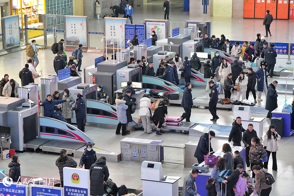 1月12日，在長春火車站候車大廳，即將踏上返鄉(xiāng)旅途的人們在安檢處依次接受安全檢查。人民網(wǎng)記者 李洋攝