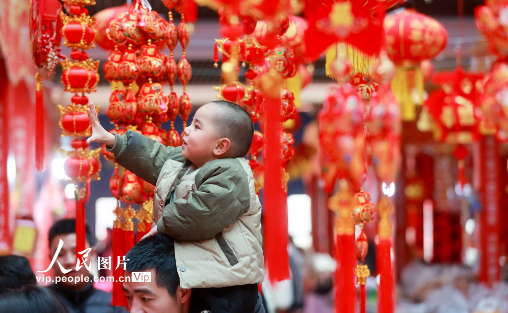 2025年1月18日，在貴州省貴陽市觀山湖區(qū)西南國際商貿(mào)城，家長帶著小朋友選購年貨。