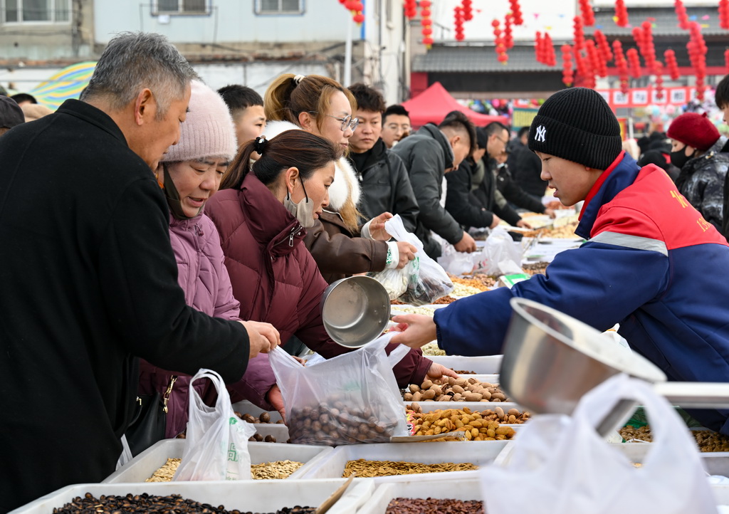 1月21日，人們?cè)诮鹳F集貿(mào)市場(chǎng)選購(gòu)干果。