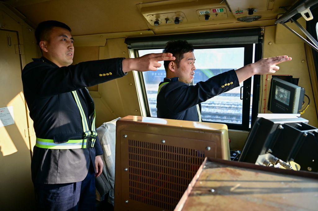 在新疆紅沙泉站，“百輛萬噸”貨運(yùn)列車的機(jī)車乘務(wù)員在確認(rèn)發(fā)車信號(hào)（1月21日攝）。